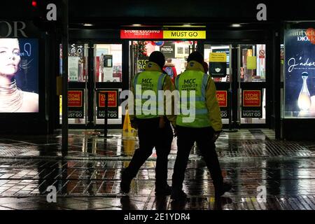 Covid-19 Marshalls walk past Debenhams in Manchester on Monday. Stock Photo