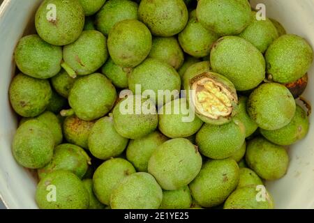 Fresh walnuts with green peel. Freshly harvest, raw, delicious and natural food. Top view, flat lay. Healthy snacks. Stock Photo