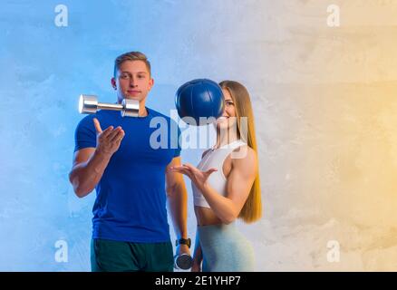 Attractive young couple in sport wear doing exercise in the gym. Strength and motivation concept. Workout online theme Stock Photo