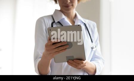 Close up young female physician using digital tablet. Stock Photo