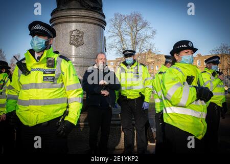 A protester is arrested and handcuffed by Police on Clapham High Street during the anti-lockdown demonstration on January 9, 2021 in London, Stock Photo