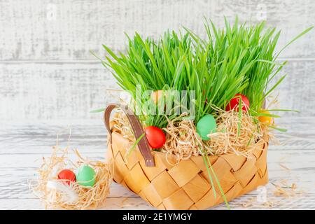 Easter basket with green grass filled with brightly colored Easter eggs. Happy Easter Stock Photo