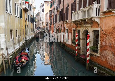 Traditional Venetian gondola with tourists on rio della Fava canal in Venice, Italy Stock Photo