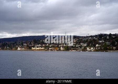 View on the part of the Golden Coast on Lake Zurich in Switzerland with village Zollikon. Photo taken from the lake that is in the foreground. Stock Photo