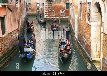 Gondoliers on traditional Venetian gondolas with tourists on the rio della Fava canal in Venice, Italy Stock Photo