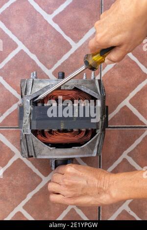 washing machine motor repair , mechanic working on electric engine Stock Photo