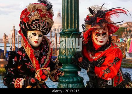 Two women dressed in traditional decorated costumes and painted masks during the Venice Carnival in Venice, Italy Stock Photo