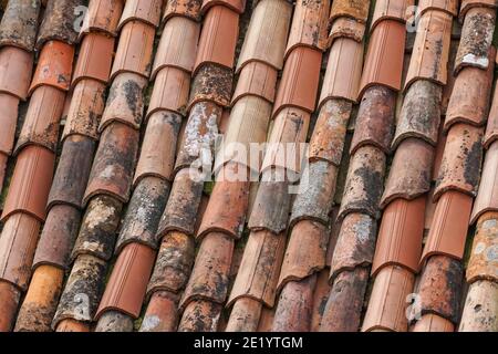 old and new clay roof tiles on the roof Stock Photo
