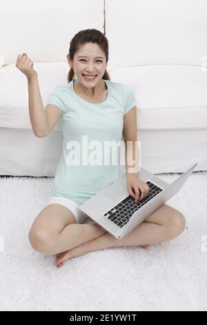 Young woman using laptop beside a couch high quality photo Stock Photo
