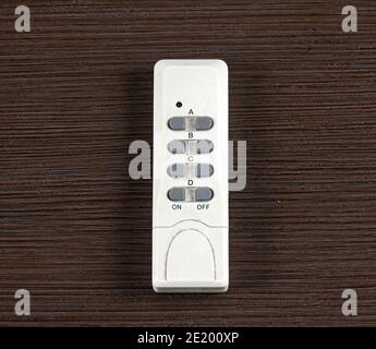 On - Off remote control with several control buttons on wooden background Stock Photo