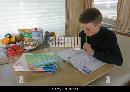 United Kingdom / Newport Pagnell /Pinders Circus / Boy doing his homework in caravan. Stock Photo