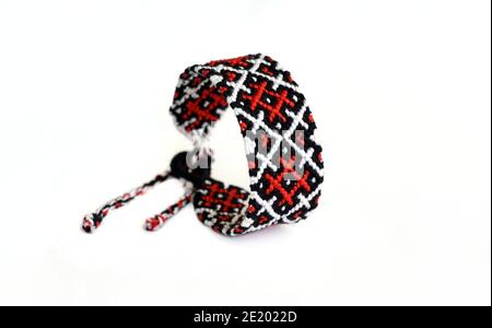 Selective focus of woven DIY friendship bracelet handmade of embroidery bright thread with knots isolated on white background. boho pattern Stock Photo