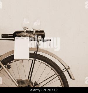 Vintage blue bicycle with bottle of wine and two glasses at the back. Space for text. Stock Photo