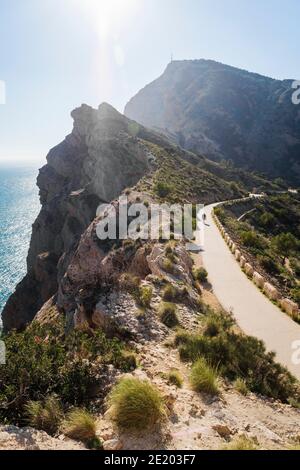 Man on scenic walking path along steep cliffs along the ocean in the natural park 'Serra Gelada' in Albir, Costa Blanca, Spain Stock Photo
