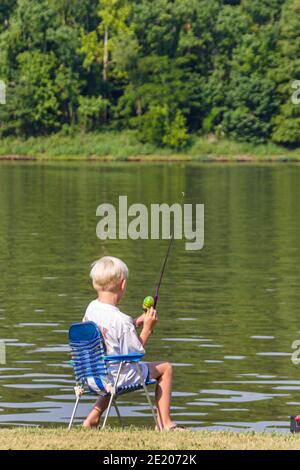 Teenage boy fishing in river at sunset, Washington, USA stock photo