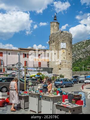 potters market at Plan de Brie against the backdrop of Tour de l'horloge, the historic Clock tower of the ancient town of Anduze, dating back to 1320, Stock Photo
