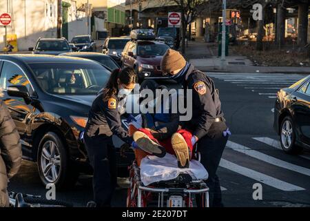 New York, United States. 10th Jan, 2021. Emergency Medical Technicians put cyclist who was hit by car on stretcher on Webster Avenue in the Bronx. Driver of the car stayed on the scene and stated that cyclist was crossing intersection on red light. (Photo by Lev Radin/Pacific Press) (Photo by Lev Radin/Pacific Press) Credit: Pacific Press Media Production Corp./Alamy Live News