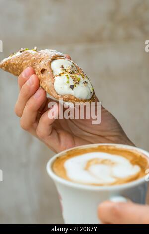 Cups of cappuccino and fresh ricotta cannoli dessert in coffee bar in Sicily, Italy. Stock Photo