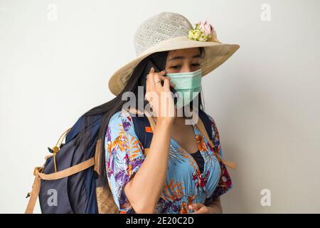 Asian woman tourist wearing face mask making OK sign with hand gesture. Stock Photo
