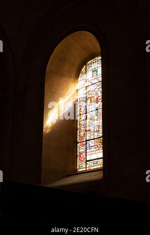 Light shines through a stained glass window at Notre Dame de Liesse church in Annecy, France. Stock Photo