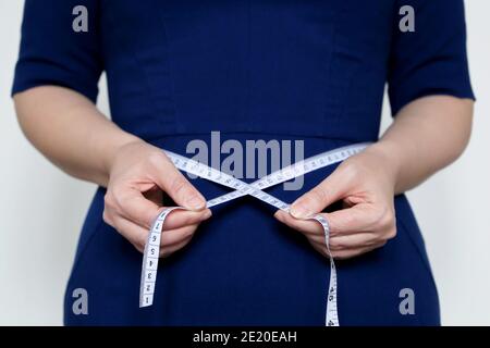 Overweight woman with tape measure around waist. Stock Photo by ©flisakd  179142730