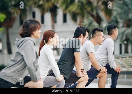 Young people doing deep lunges Stock Photo
