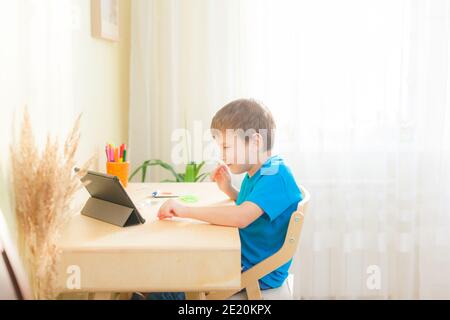 Child using tablet for study. Education and distance learning concept. Homeschooling during quarantine Stock Photo