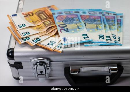 50 and 20 euro banknotes on aluminum briefcase on white background Stock Photo