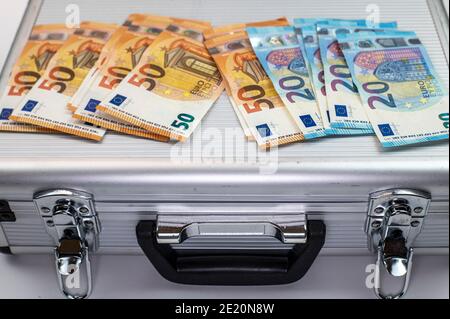 50 and 20 euro banknotes on aluminum briefcase on white background Stock Photo