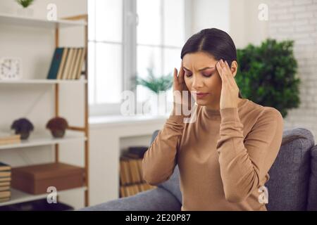 Woman touching her temples, suffering from stress, bad headache or severe migraine Stock Photo