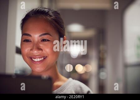 Evening Shot Of Businesswoman Standing In Corridor Of Modern Office Using Digital Tablet Stock Photo