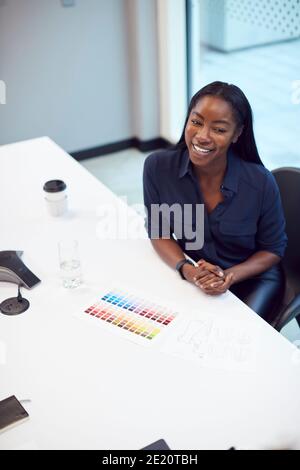 High Angle View Of Smiling African American Businesswoman Sitting At Table In Office  Meeting Room Stock Photo