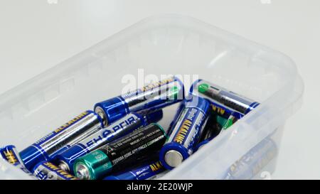 Clear plastic box full of used household AA alkaline and lithium-ion batteries collected for recycling in special waste bins. Recycling and ecology pr Stock Photo