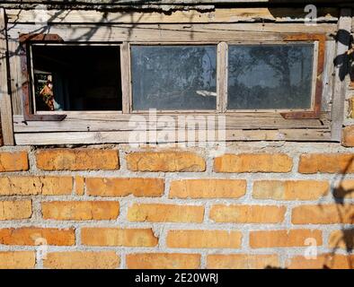 Background of old aged brick wall of abandoned bulding with window at sunny day. Stock Photo