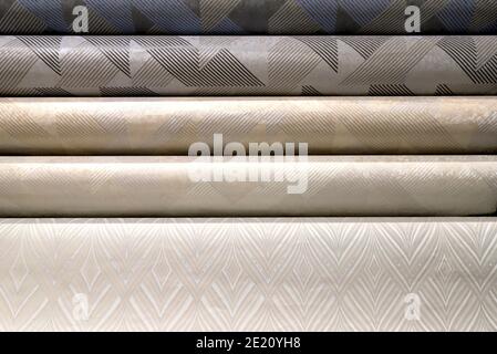 Rolled up rolls of vinyl wallpaper. Different textures and colors, as