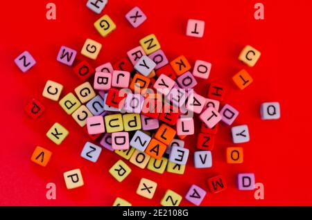 Colorful wooden cube beads with letters on red festive background, word 'love'. Valentine Day. 14 of February. Flat lay, top view. Stock Photo