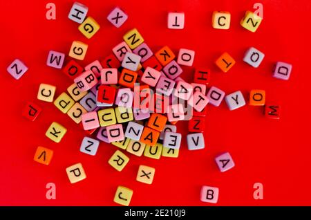 Colorful wooden cube beads with letters on red festive background, word 'love'. Valentine Day. 14 of February. Flat lay, top view. Stock Photo