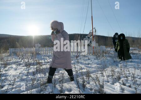 Dahinggan. 10th Jan, 2021. Staff members of local meteorological bureau walk on snow-covered field after maintaining the facilities at an observatory in Huzhong District at the northern foot of the Dahinggan Mountains in northeast China's Heilongjiang Province, Jan. 10, 2021. Huzhong District is known as 'China's coldest town,' and the lowest temperature in the district dropped below minus 40 degrees Celsius in recent days. Credit: Wang Jianwei/Xinhua/Alamy Live News Stock Photo