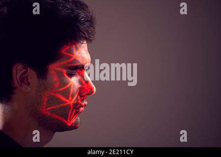 Facial Recognition Technology Concept As Man Has Red Grid Projected Onto Face In Studio Stock Photo