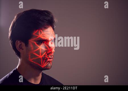 Facial Recognition Technology Concept As Man Has Red Grid Projected Onto Face In Studio Stock Photo