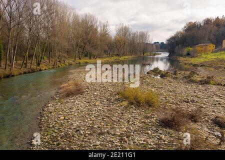 The river Ter runs quietly on a winter day bordered by forests and mountains near Torello, Catalonia, Spain Stock Photo