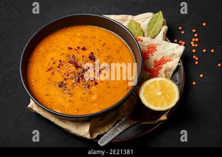 Ezogelin Soup in black bowl on dark slate table top. Turkish cuisine traditional dish with red lentils, bulgur and rice Stock Photo