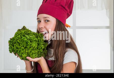 We detest vegetables. healthy and organic food only. professional menu. teen girl chef wearing uniform. child study how to cook by recipe. kid cooking in kitchen. choosing future career. ready to eat. Stock Photo