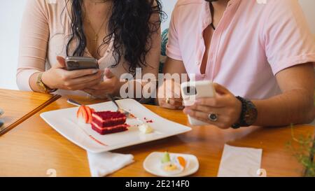 Young couple enjoying time together and using their smartphones Stock Photo