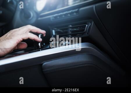 Caucasian Men Changing Automatic Transmission Gears in the Modern Car Interior Close Up. Automotive Industry Theme. Stock Photo