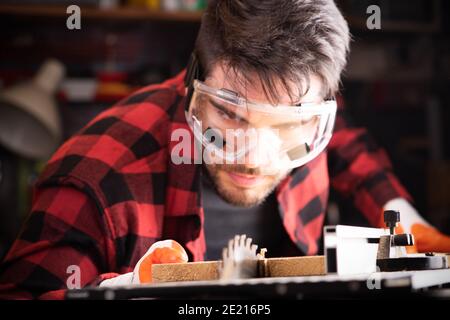 Carpenter engaged in processing wood at the sawmill close up Stock Photo