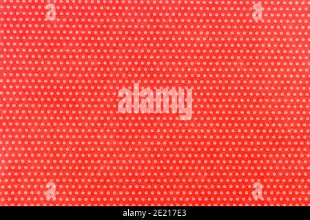 Textile homogeneous background color red in white fine polka dots, horizontal pattern. View from above. Emotionally funny. Stock Photo