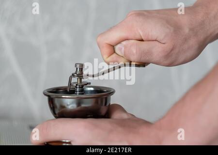 mechanical machine for grinding coffee beans in the hands of a person Stock Photo