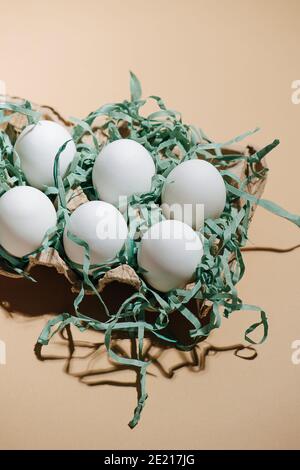 Six eggs in the package on a beige background Stock Photo