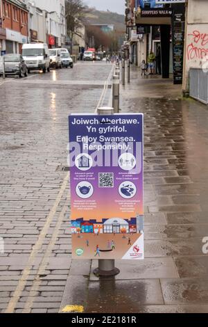 Swansea, UK. 11th Jan, 2021. Social distancing sign on Oxford Street in the quiet city centre of Swansea this morning as lockdown during the height of the Coronavirus pandemic continues across the UK. Credit: Phil Rees/Alamy Live News Stock Photo